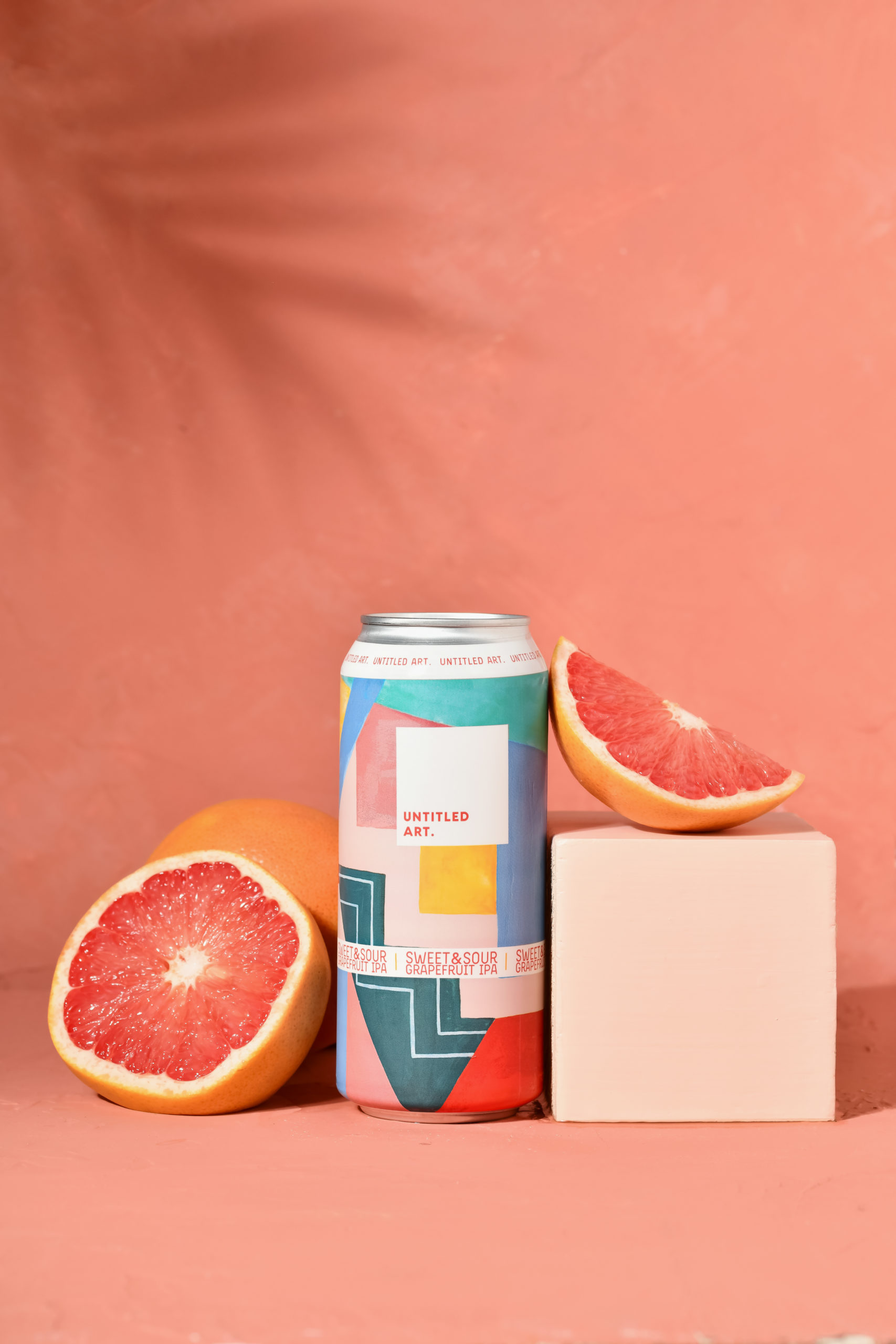 A can of grapefruit beer on a pink background.