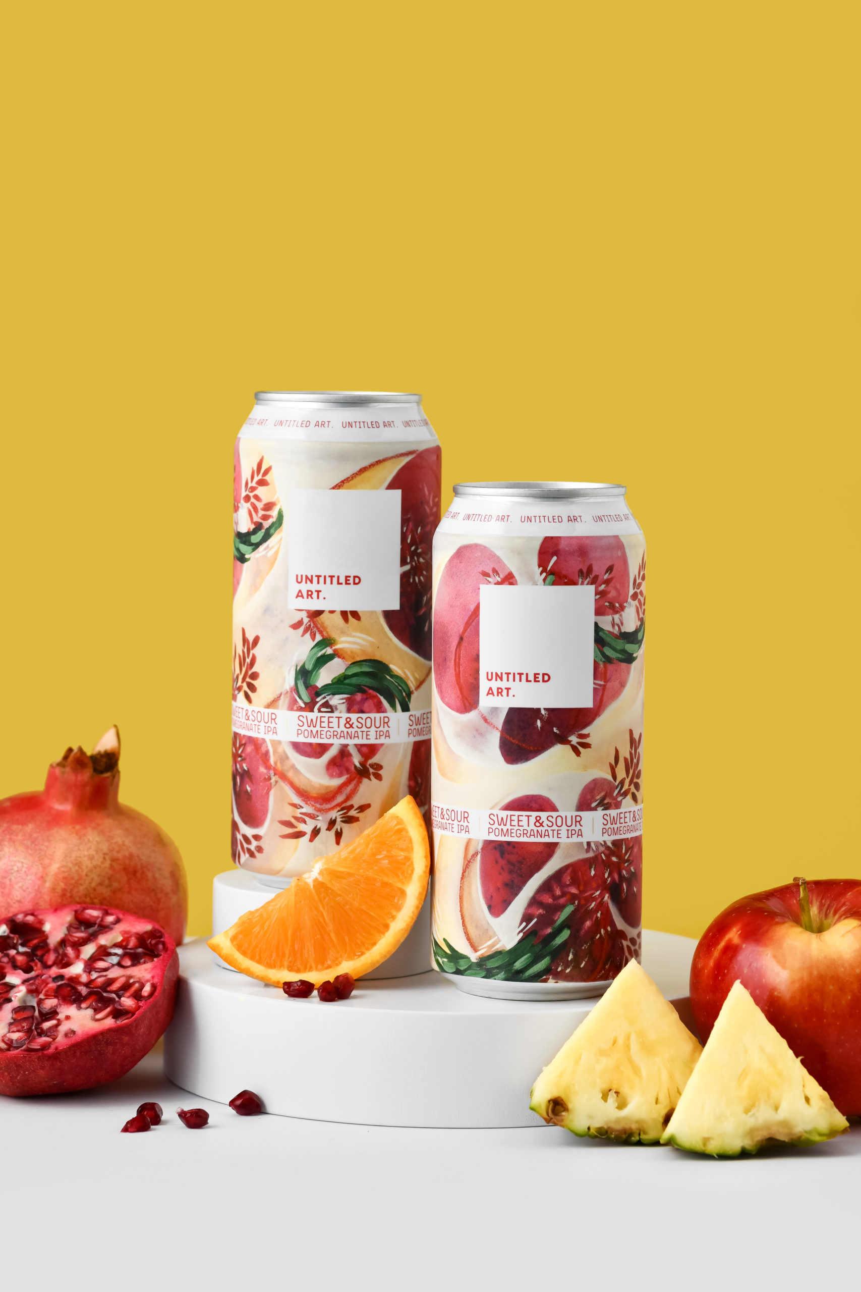 A can of beer with oranges, pineapples and pomegranates on a yellow background.