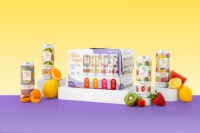 A box of fruit and juices on a purple background.