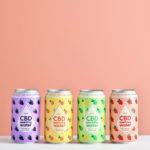 Four cans of cbd water on a pink background.