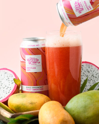 A can of dragon fruit beer is being poured into a glass.