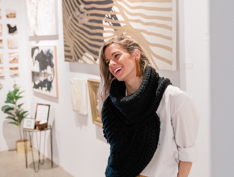A woman wearing a scarf in an art gallery.