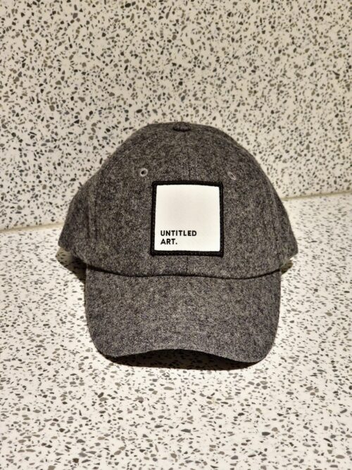 An Untitled Art Logo Patch Hat - Grey Wool Blend with a white patch on it.