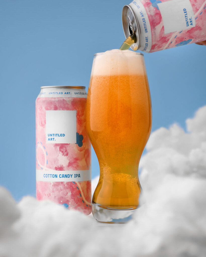 A beer is being poured into a can in the sky.
