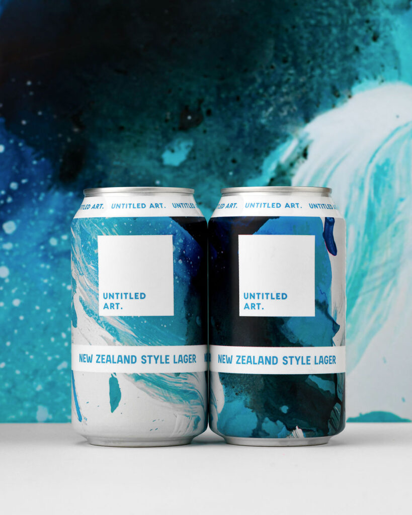 Two cans of beer in front of a blue background.