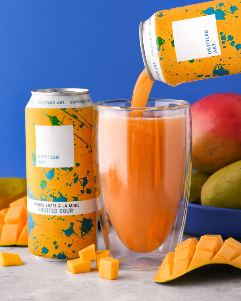 A can of mango juice being poured into a glass.
