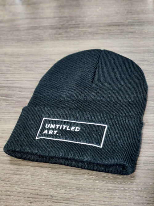 A black Untitled Art Logo Knit Cuffed Beanie with the word 'unlimited art' on it.
