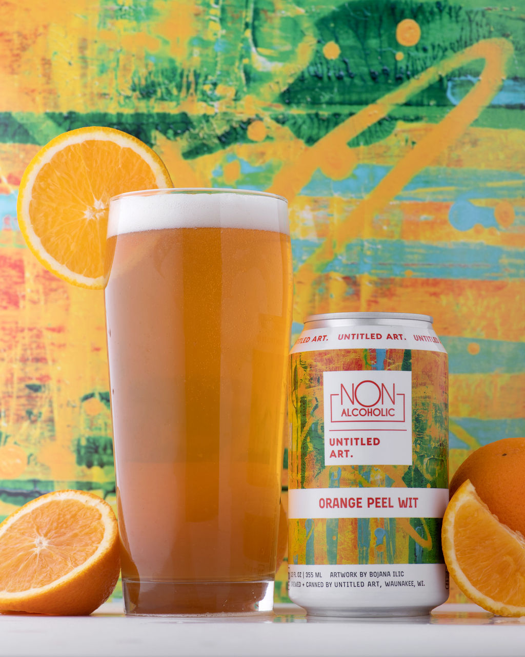 A can of orange beer next to a slice of orange.